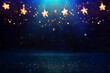 Leinwandbild Motiv Christmas warm gold garland lights over dark background with glitter overlay