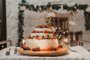 Wall Mural - Closeup of a delicious wedding cake decorated with fresh berries isolated on a table