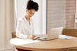 © Rene L/peopleimages.com - Woman writing in notebook, laptop on table and home office of accountant, auditor or financial advisor. Finance report, strategy and budget planning, black woman doing research on tax audit documents