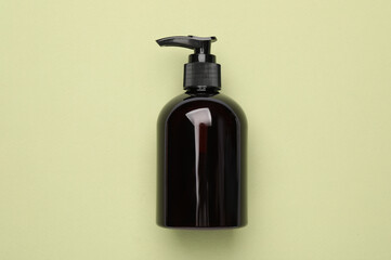 Wall Mural - Bottle of shampoo on light green background, top view