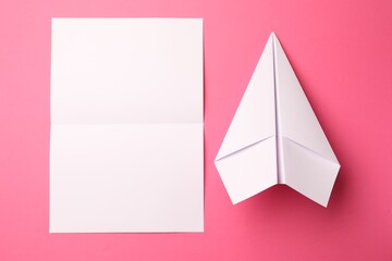 Poster - Handmade white plane and folded piece of paper on pink background, flat lay