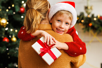 Sticker - Cheerful child congratulating  mother at Christmas