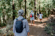 Back view of a group of older caucasian people walking the trail on a mountain hike enjoying free time and freedom in nature, senior retirees and healthy lifestyle concept