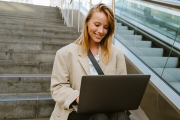 Wall Mural - Young beautiful smiling happy business lady working with laptop