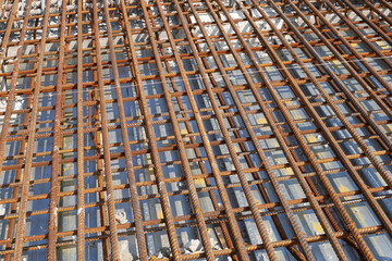 MELAKA, MALAYSIA -JULY 2, 2022: Steel reinforcement bars are arranged according to the structural engineer's design. The steels are tied together using a small steel wire.