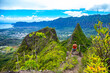 hiker girl stands at the top of olomana ridge trail admiring the panorama of oahu and hawaii mountains; famous three peaks on oahu, dangerous hiking on hawaii mountains, hawaii holidays