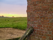 English Rural Landscape At Sunrise With Brick Wall Of Old Farm Building
