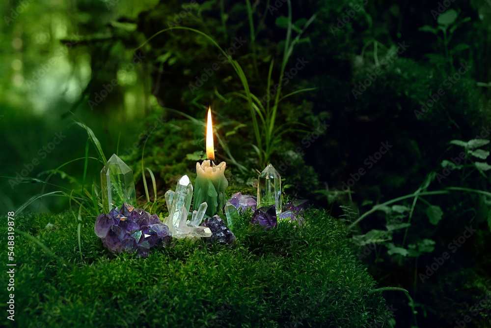 Minerals and candle close up in mysterious forest, dark natural ...