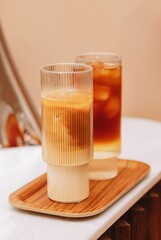 Sticker - Vertical shot of ice latte and cold brew tonic on a tray on the white table