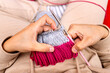 © Alfonso Soler - Close-up of a woman's hands knitting with needles.