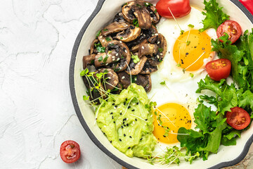 Wall Mural - Closeup of tasty fried eggs with avocado and mushrooms. Ketogenic diet. Low carb high fat breakfast. Healthy food concept. place for text, top view.