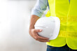 © siewwy84 - Engineer holding hardhat wearing yellow vest and standing ready for work safety in site.
