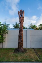 Vertical Shot Of A Wooden Sculpture Made Of Tree Trunk In The Style Of Maori Culture