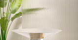 Modern, minimal round silver colored steel table podium with banana tree and reeded glass partition in dappled sunlight on cream colored wall for luxury, organic, beauty, cosmetic product display