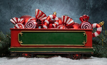 Red Baubles Ornaments, Candy Canes, Christmas Tree Pendant Decorations In A Decorative Christmas Train Car Wagon Carriage. Festive Holiday Season Winter Composition With Snow, Branches And Copy Space.