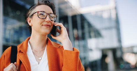 Business woman making a phone call while commuting to work in the city