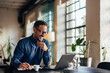© bnenin - Smiling businessman, working over the laptop, being at his office.