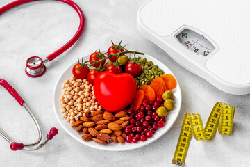 Wall Mural - Fat control diet. Healthy food in heart shaped plate with weight scale