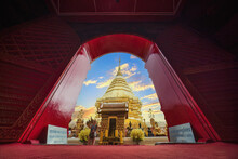 Image Of Chedi Phra That Doi Suthep Was Photographed Through The Red Church Gate With Sunset Sky. Contrasting Between The Golden Pagoda Of Phra That Doi Suthep In Chiang Mai, Thailand.