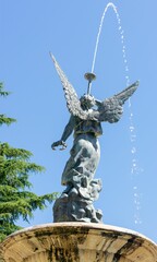 Poster - Vertical shot of a stone angel statue in a park in Valladolid, Spain, in sunny weather