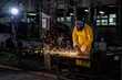 © Tongpool - Maintenance mechanical man wearing leather body protection use grinding machine cutting fire spark