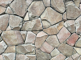 Wall Mural - Granite stone wall surface. These stones have been joined together using mortar. The construction of this wall requires precision so that it can be built upright with an almost flat surface.
