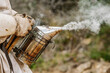 © ADDICTIVE STOCK - Anonymous beekeeper in apiary with bee smoke transmitter