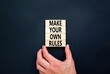 Make your own rules symbol. Concept words Make your own rules on wooden cubes. Beautiful black table black background. Businessman hand. Business motivational make your own rules concept. Copy space