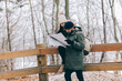 © Photocreo Bednarek - Couple trekking in winter in the forest looking at map.