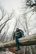 © Photocreo Bednarek - Man trekking in winter forest resting on tree.