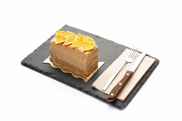 Poster - Slice of cake with orange on wooden board isolated in white background