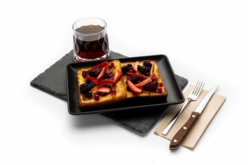 Wall Mural - Closeup of toasts with strawberries and blackberries with glass of tea isolated in white background