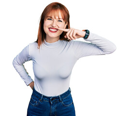 Wall Mural - Redhead young woman wearing casual turtleneck sweater pointing with hand finger to face and nose, smiling cheerful. beauty concept