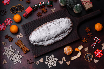 Wall Mural - Christmas pie stollen with marzipan, berries and nuts on a dark concrete background