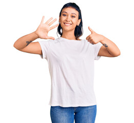 Sticker - Young woman wearing casual clothes showing and pointing up with fingers number six while smiling confident and happy.