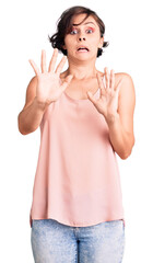 Canvas Print - Beautiful young woman with short hair wearing casual style with sleeveless shirt afraid and terrified with fear expression stop gesture with hands, shouting in shock. panic concept.