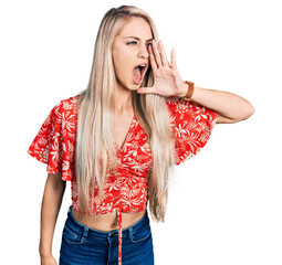 Wall Mural - Beautiful young blonde woman wearing summer shirt shouting and screaming loud to side with hand on mouth. communication concept.