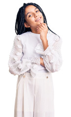 Wall Mural - Cute african american girl wearing casual white tshirt looking confident at the camera with smile with crossed arms and hand raised on chin. thinking positive.