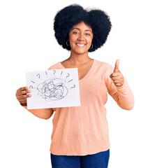 Wall Mural - Young african american girl holding scribble draw smiling happy and positive, thumb up doing excellent and approval sign