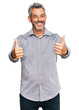 Middle age grey-haired man wearing casual clothes approving doing positive gesture with hand, thumbs up smiling and happy for success. winner gesture.