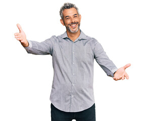 Poster - Middle age grey-haired man wearing casual clothes looking at the camera smiling with open arms for hug. cheerful expression embracing happiness.