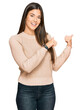 © Krakenimages.com - Young brunette woman wearing casual winter sweater pointing to the back behind with hand and thumbs up, smiling confident