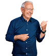 © Krakenimages.com - Senior man with grey hair wearing casual shirt and glasses smiling with happy face looking and pointing to the side with thumb up.
