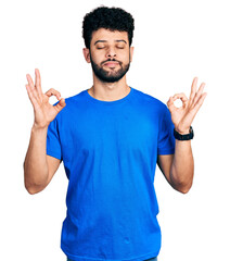 Poster - Young arab man with beard wearing casual blue t shirt relaxed and smiling with eyes closed doing meditation gesture with fingers. yoga concept.