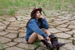 girl with a whip lying on ground cracks, western  cowgirl in a sheriff hat