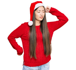 Sticker - Young chinese woman wearing christmas hat stretching back, tired and relaxed, sleepy and yawning for early morning