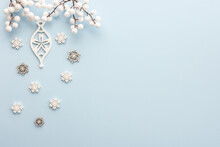 Decorative White Christmas Decorations With Snowflakes And White Berries On A Blue Background, Merry Christmas And Happy New Year Concept, Top View, Copy Space