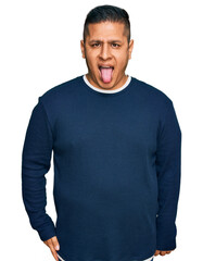 Canvas Print - Young latin man wearing casual clothes sticking tongue out happy with funny expression. emotion concept.