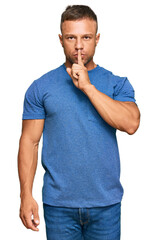 Wall Mural - Handsome muscle man wearing casual clothes asking to be quiet with finger on lips. silence and secret concept.