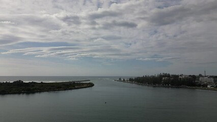 Wall Mural - Aerial footage of the gray water surface under the cloudy sky in Port Macquarie, NSW